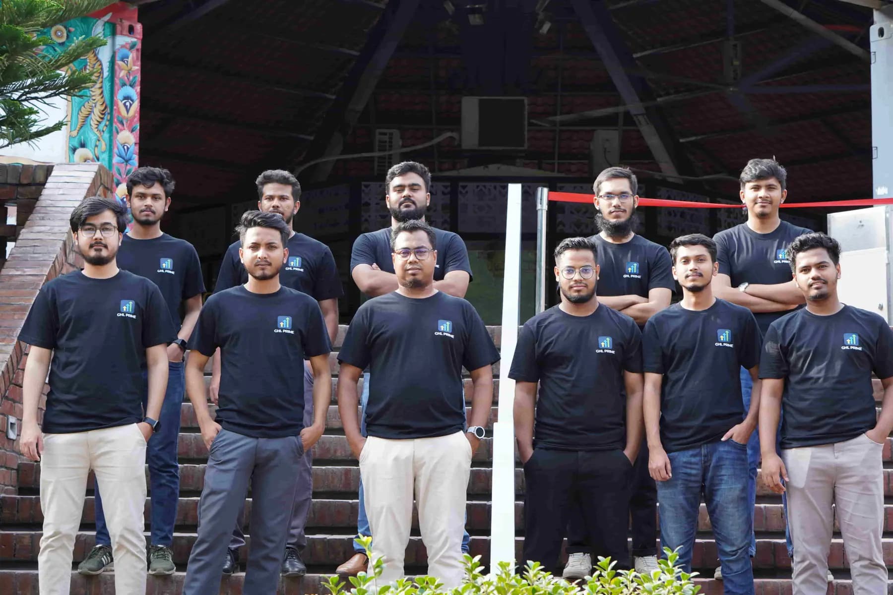 The GHLPrimeAI team standing together on outdoor steps in matching black team shirts